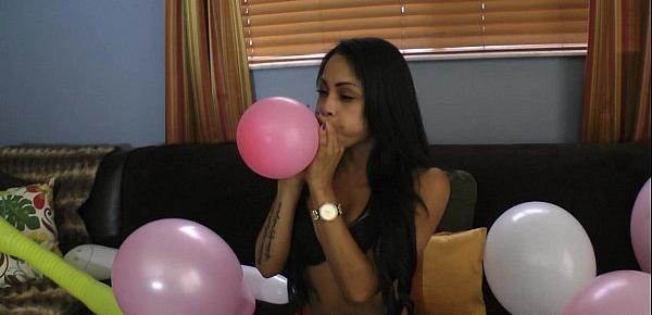  Latina blowing to pop balloons